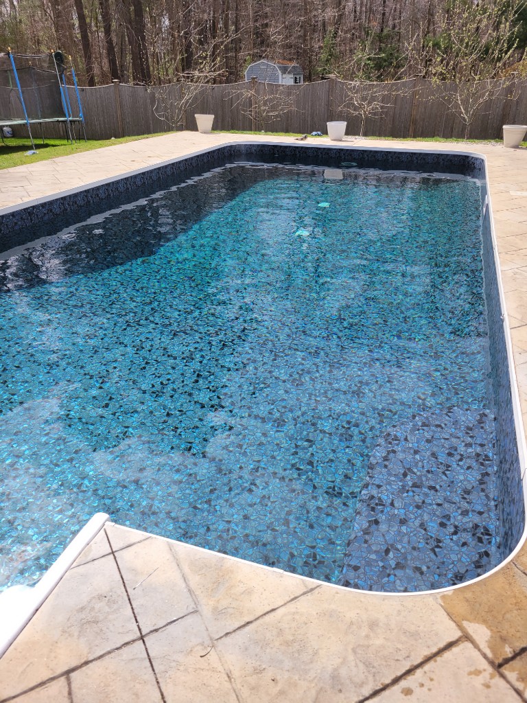 Finished in-ground pool with a new blue vinyl liner